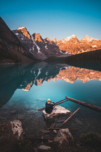 Rear view of man on lake against sky