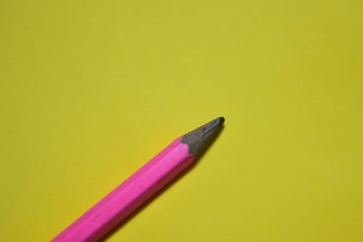 Close-up of colored pencils against yellow background