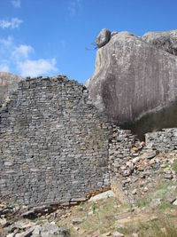 Low angle view of bird on rock against sky