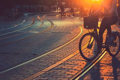 Low section of woman riding bicycle on street