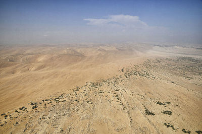 Scenic view of sand dunes against sky