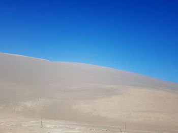 Scenic view of desert against clear blue sky