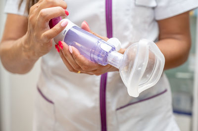 Midsection of woman holding bottle