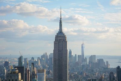 Empire state building against modern towers at manhattan