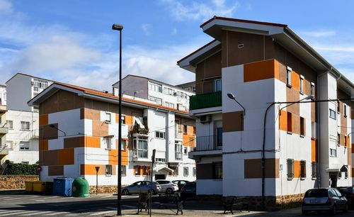 Houses by street against sky in city