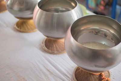 High angle view of rice in steel containers on table