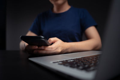 Midsection of man using mobile phone