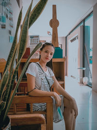 Portrait of smiling young woman sitting at home