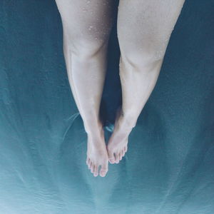 High angle view of woman legs on sea water