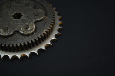 Close-up of machine part over black background