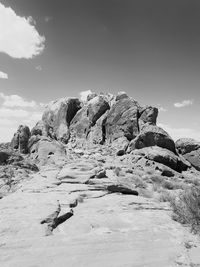 Rock formation on snow covered land against sky