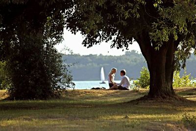 People relaxing on lakeshore