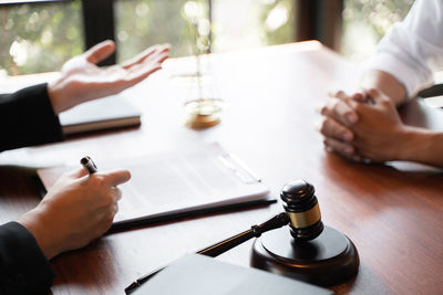 Cropped image of people holding glass table