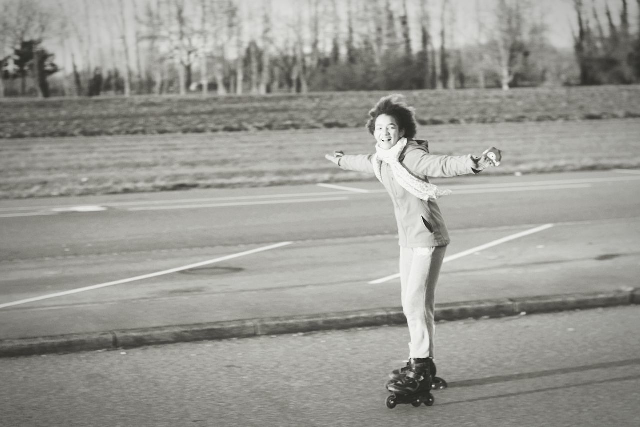 full length, lifestyles, casual clothing, road, leisure activity, street, young adult, side view, standing, person, rear view, transportation, walking, skateboard, front view, sunlight, outdoors, day