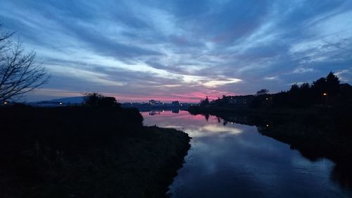 Scenic view of river against sky at sunset