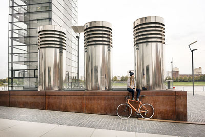 Young woman with bicycle having a break in the city