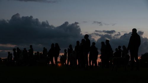 People on field against sky during sunset