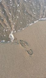 High angle view of footprints on sand at beach