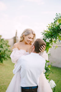 Bridegroom embracing during wedding ceremony outdoors