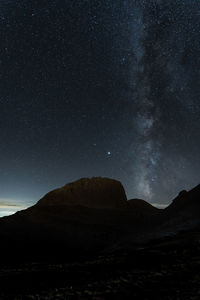 Scenic view of landscape against star field at night