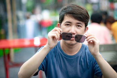 Portrait of young man holding camera