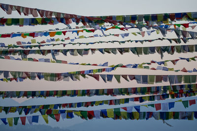 Low angle view of flags hanging against sky