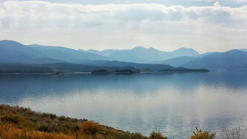 Scenic view of lake against cloudy sky