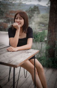 Young woman sitting on table