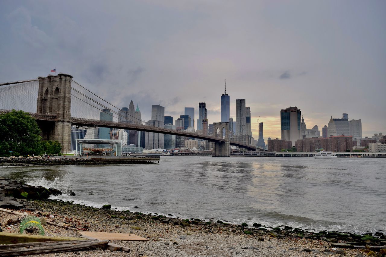 architecture, city, built structure, skyscraper, sky, connection, river, building exterior, modern, water, bridge - man made structure, cityscape, outdoors, no people, urban skyline, day