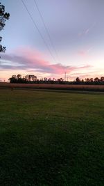 Scenic view of field against sky at sunset