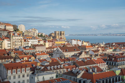 High angle view of townscape by sea against sky