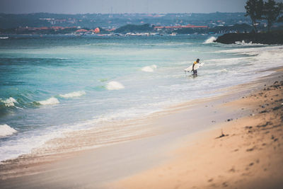 Surfer with surfboard walking at beach