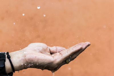 Close-up of water splashing on human palm