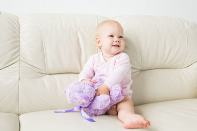 Cute baby girl on sofa at home