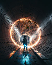 Full length of woman standing in illuminated tunnel