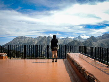 Man standing on mountain against cloudy sky