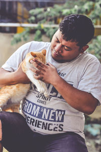 Side view of man feeding cat