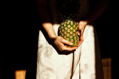 Midsection of woman holding fruit