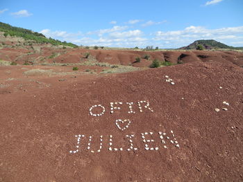 Text written on field against sky