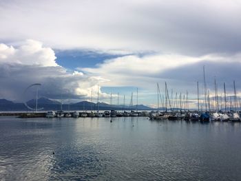 Sailboats moored on sea against sky