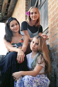 Portrait of smiling young women sitting on stairs