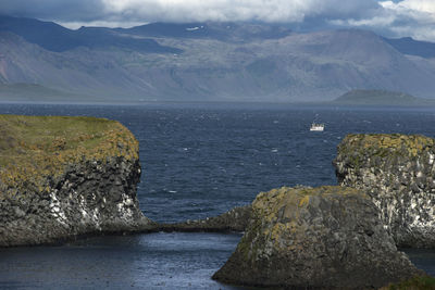 Scenic view of sea and mountains against sky