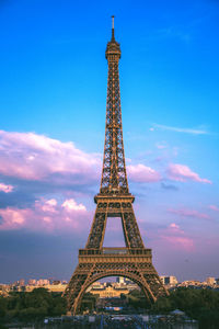 Eiffel tower in city against sky during sunset