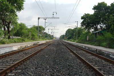 Railroad tracks amidst trees against sky