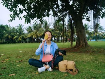 Full length portrait of young woman using mobile phone in park