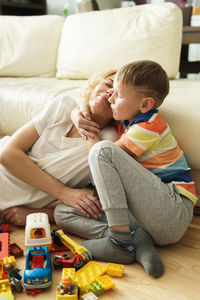 Mother and daughter sitting on bed at home