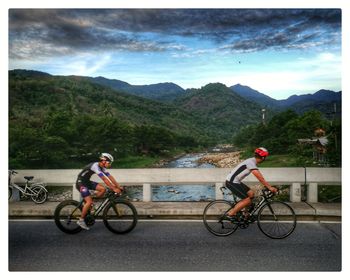 Man riding bicycle on mountain against sky