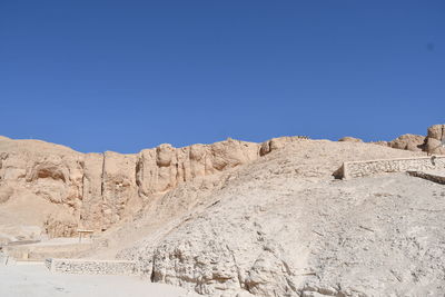 Panoramic view of arid landscape against clear blue sky