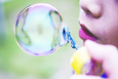 Close-up of child blowing bubbles