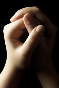 Close-up of woman hand over black background